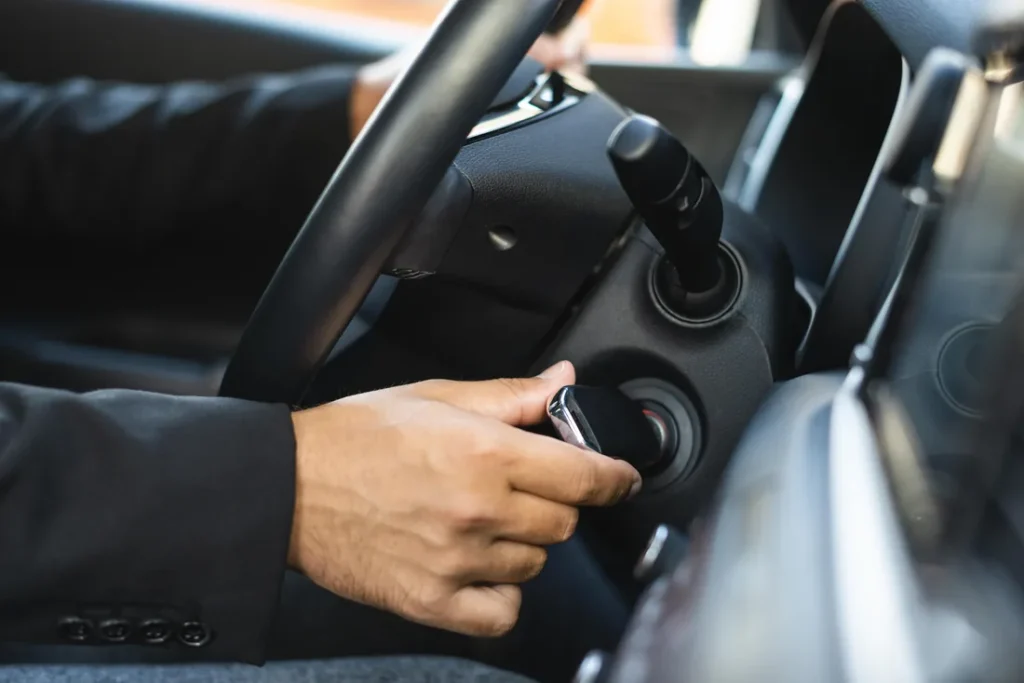 Driver starting a car with a key in the ignition