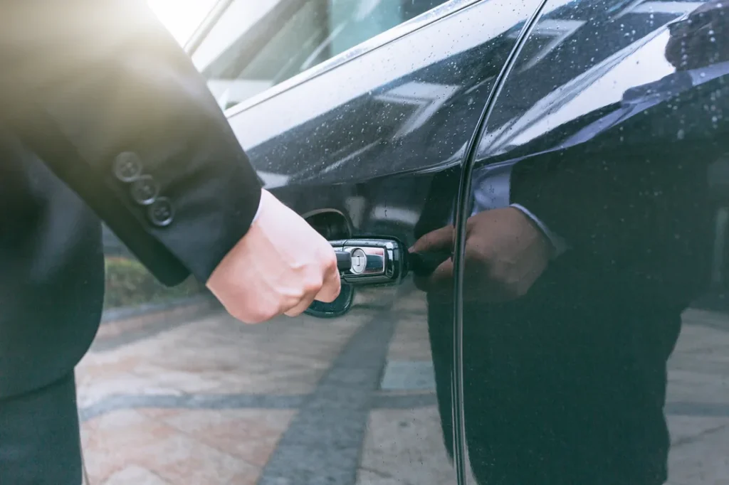 Locksmith unlocking a car door for a customer
