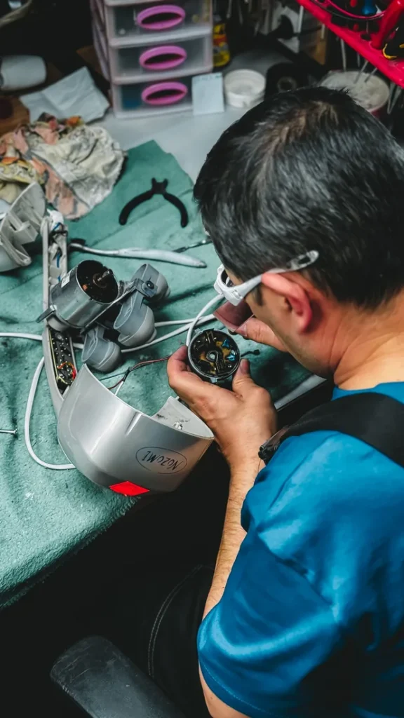 Technician repairing an ignition assembly at a workbench