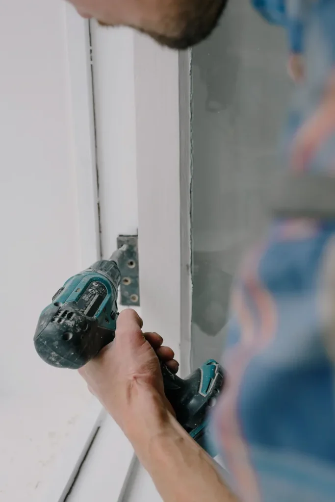 Locksmith working on a door lock with a power tool